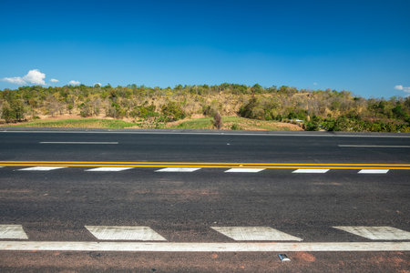Asphalt road over the hills with blue sky and mountains, Road background.の写真素材