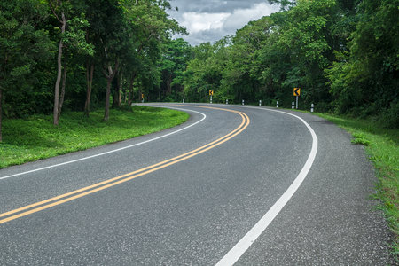 Beautiful curved road in the forest. Road background.の写真素材