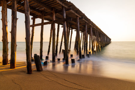 Long wooden bridge go to the sea in beautiful tropical island at sunset.の写真素材