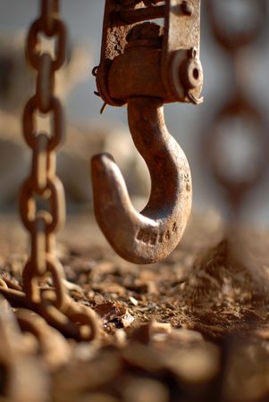 a hanging down on a chain  ferruginous hook is in evening illuminationの写真素材