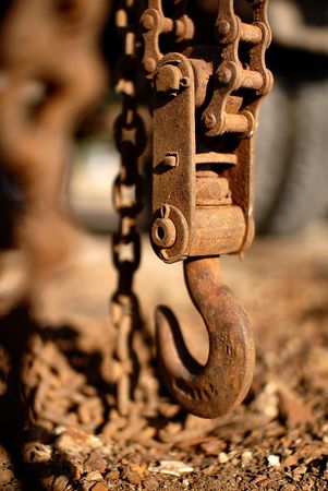 a hanging down on a chain  ferruginous hook is in evening illuminationの写真素材