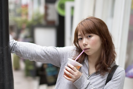 Young asian woman drinking juice