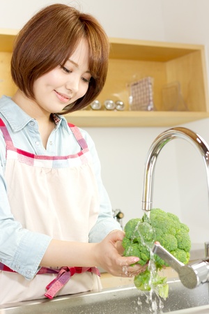 Beautiful woman standing in kitchenの写真素材