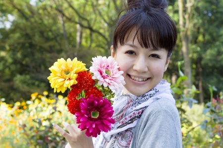 Beautiful asian woman in flower garden の写真素材