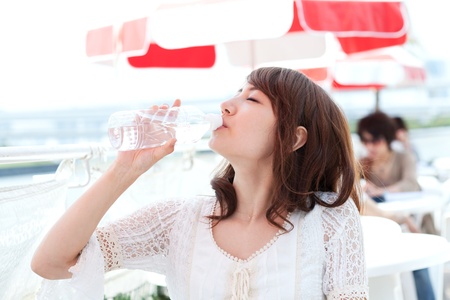 Beautiful young woman drinking waterの写真素材