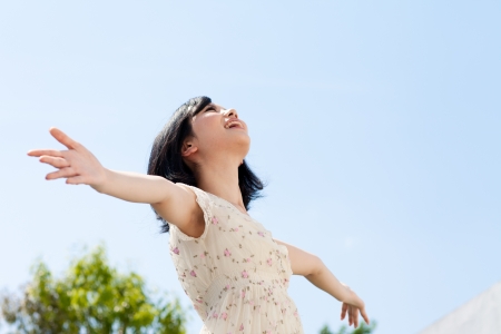 Beautiful young woman outdoors over blue sky