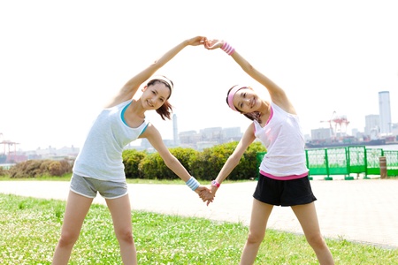 Beautiful young woman doing stretching exercise in the parkの写真素材