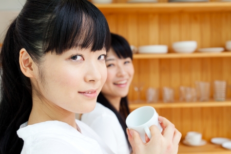 Beautiful young women relaxing in the kitchenの写真素材