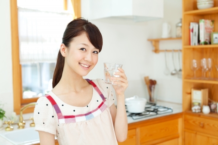 Beautiful young woman in the kitchenの写真素材