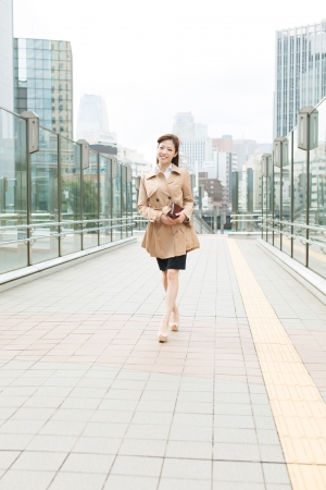 Beautiful business woman walking outside her officeの写真素材