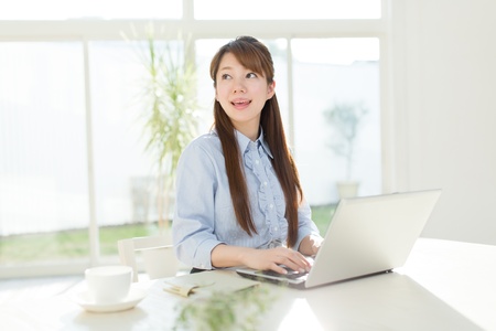 Beautiful asian businesswoman using a laptop computerの写真素材