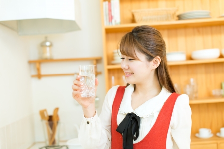Beautiful young woman in the kitchenの写真素材