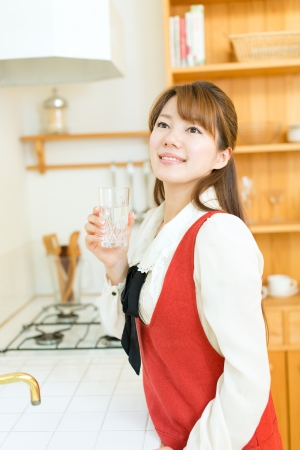 Beautiful young woman in the kitchenの写真素材