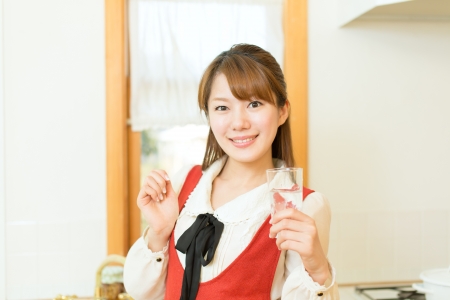Beautiful young woman in the kitchenの写真素材