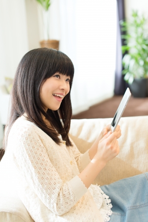 Beautiful asian woman relaxing in the roomの写真素材