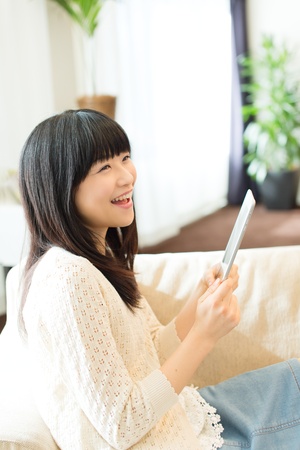 Beautiful asian woman relaxing in the roomの写真素材