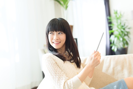 Beautiful asian woman relaxing in the roomの写真素材