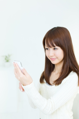 Beautiful young woman using a cellular phoneの写真素材