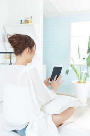 Beautiful asian woman relaxing in the roomの写真素材