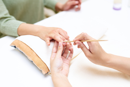 Close up of a woman in a nail salon receiving manicureの写真素材