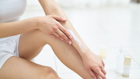 Young woman in white is engaged in the body careの写真素材