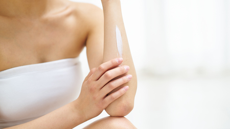 Young woman in white is engaged in the body careの写真素材