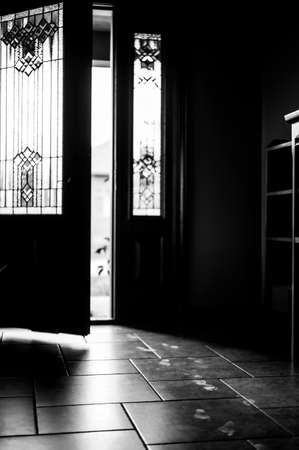 Track of small child footprints visible on a tile floor with an open door letting in light in the...