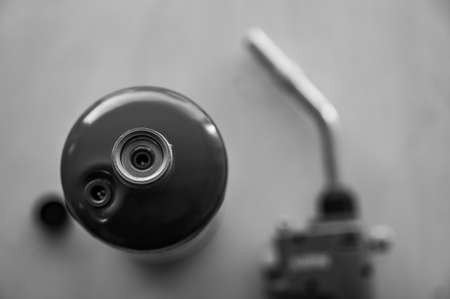 Selective focus on propane gas canister with blurred nozzle and head of blowtorch in the backgroundの写真素材