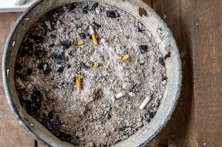 cigarette ash bucket sitting on a wooden porch in a rural setting