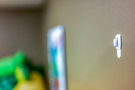 Selective focus on adhesive strip wall hanger that can be removed by pulling tape