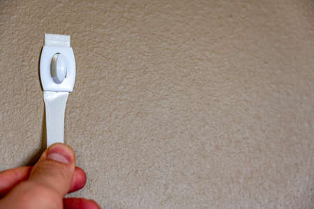 Selective focus on adhesive strip wall hanger that can be removed by pulling tape