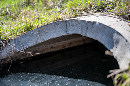 full capacity concrete culvert with sheen contaminated storm water runoff
