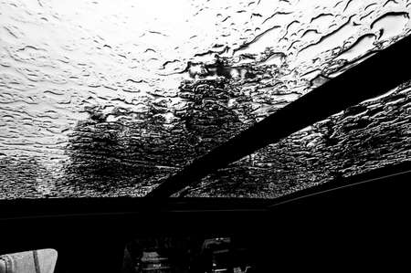 Inside a vehicle looking up to a sunroof with water dropletsの写真素材