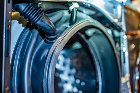 Selective Focus on the gasket mount of a front loading washing machine being serviced