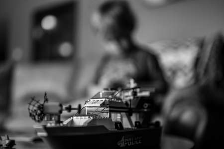 Tiffin, Iowa, USA - 9.2021 - Focus on Lego ship construction set with blurred child in the background playingのeditorial素材