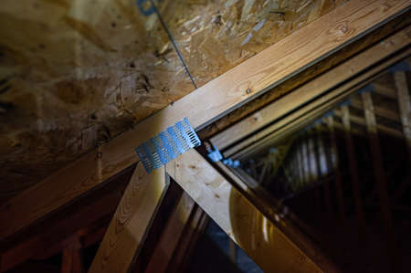 Rafter galvanized mending nail plate in an attic connecting a joint
