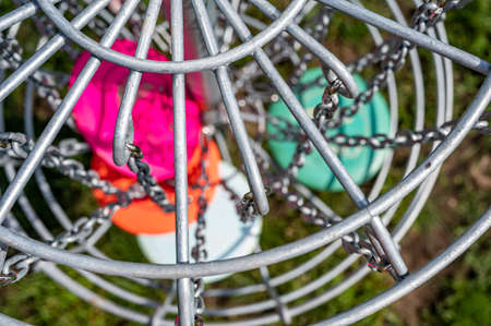 Top view of a golf basket chains with discs blurred belowの写真素材