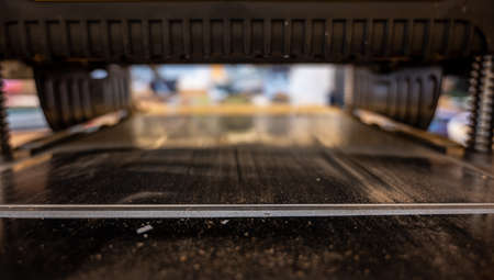 Selective focus looking into a wood planer bed raised above the board
