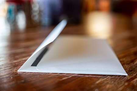 blank envelope ready to be sealed and sent in the mail. Dark colored paper edge visible.の写真素材