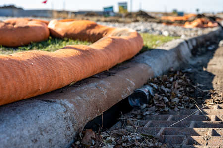 Filter sock placed to prevent erosion runoff of soil into an open storm drainの写真素材
