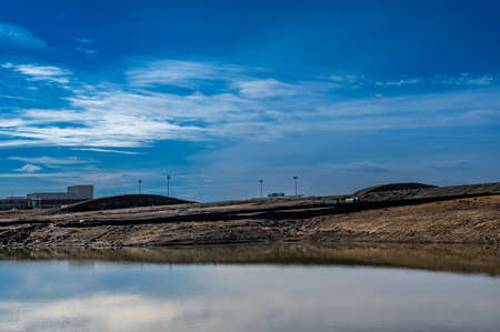 straw covered slope leading to a stormwater retention basin used to control soil erosion at a construction siteの写真素材