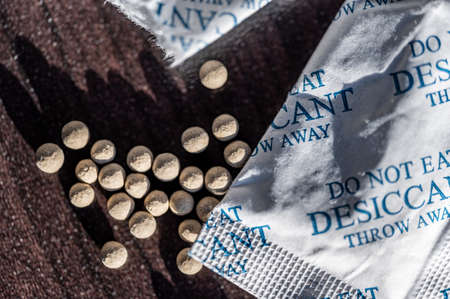 packets of desiccant scattered on a dark surfaceの写真素材