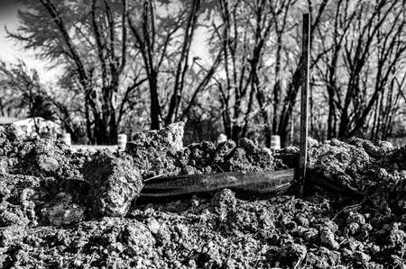 poorly maintained silt fence at a construction site with exposed dirt piled against the fabricの写真素材