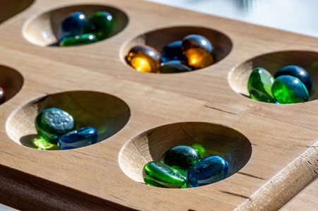 Selective focus on glass beads on a wooden mancala board