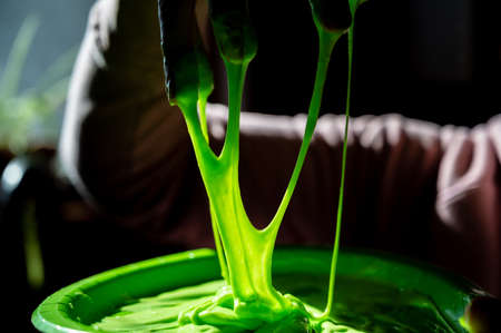 focus on slime covered hands with strings of gooey webbing downの写真素材