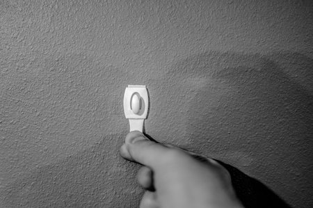 Selective focus on adhesive strip wall hanger that can be removed by pulling tape