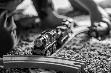 Tiffin, Iowa, USA - 3.2021: Small boy playing with a model Thomas the Train. Thomas is a popular railroad themed childrens toy.のeditorial素材