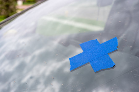 Tape covering a chip on a car windshield.の写真素材