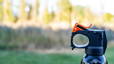 Aerosol trigger of a can of bear spray in an outdoor setting