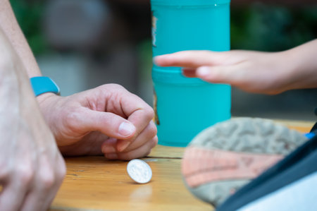 Two people playing a game with a spinning coin in order to pass time.